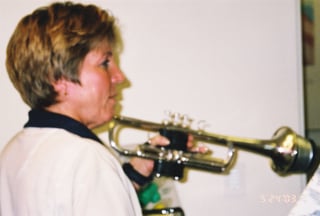 Carolyn holding trumpet to play at PowerLung booth at ITG 2003